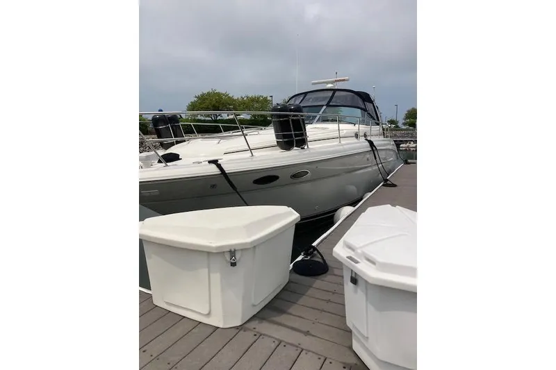 Slide: The Image of 2001 Sea Ray 380 Sundancer yacht docked with storage containers nearby. - 37