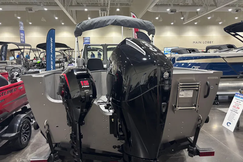 Slide: The Image of 2026 Crestliner 2050 Commander boat with dual Mercury outboard motors displayed indoors. - 10