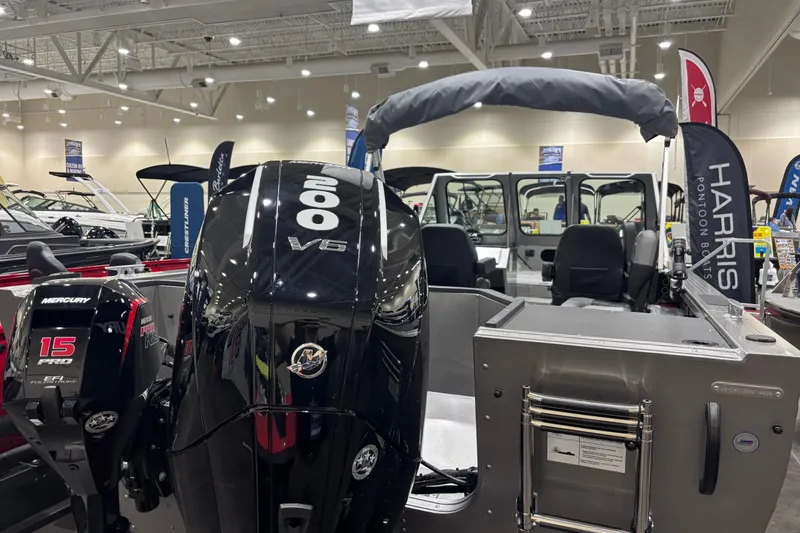Slide: The Image of 2026 Crestliner 2050 Commander boat with Mercury engines displayed indoors. - 2