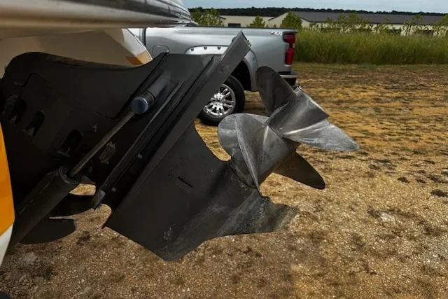 Slide: The Image of Propeller of a 2002 Cobalt 262 boat on a trailer, parked on gravel. - 13