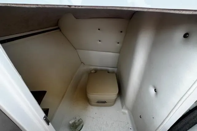 Slide: The Image of 2002 Cobalt 262 boat interior with portable toilet in compact cabin space. - 23
