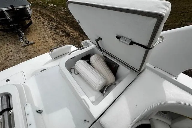 Slide: The Image of Open storage compartment on a 2002 Cobalt 262 boat with fenders inside. - 25