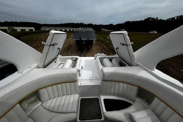Slide: The Image of 2002 Cobalt 262 boat interior with white leather seating and open storage compartments. - 27