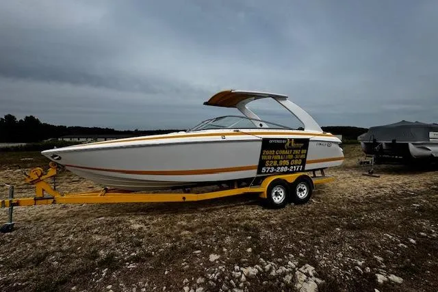 Slide: The Image of 2002 Cobalt 262 boat on trailer, displayed outdoors under cloudy skies. - 7