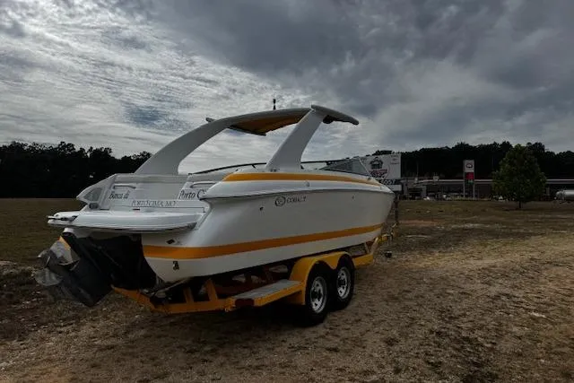 Slide: The Image of 2002 Cobalt 262 boat on trailer under cloudy sky, parked on grassy area. - 9