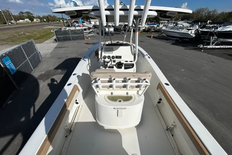 Slide: The Image of 2016 NauticStar 25 XS boat interior with console and seating, parked in a marina. - 16