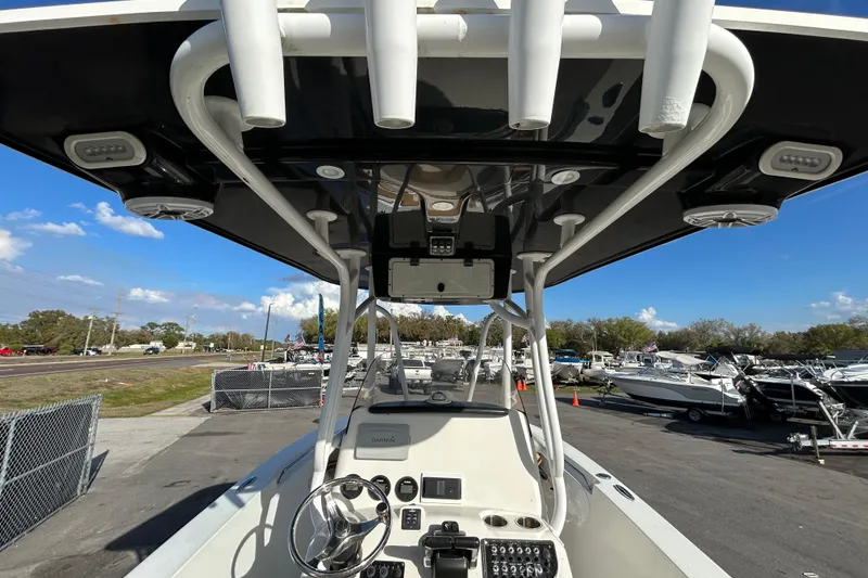 Slide: The Image of 2016 NauticStar 25 XS boat interior with steering wheel and control panel, parked at marina. - 19