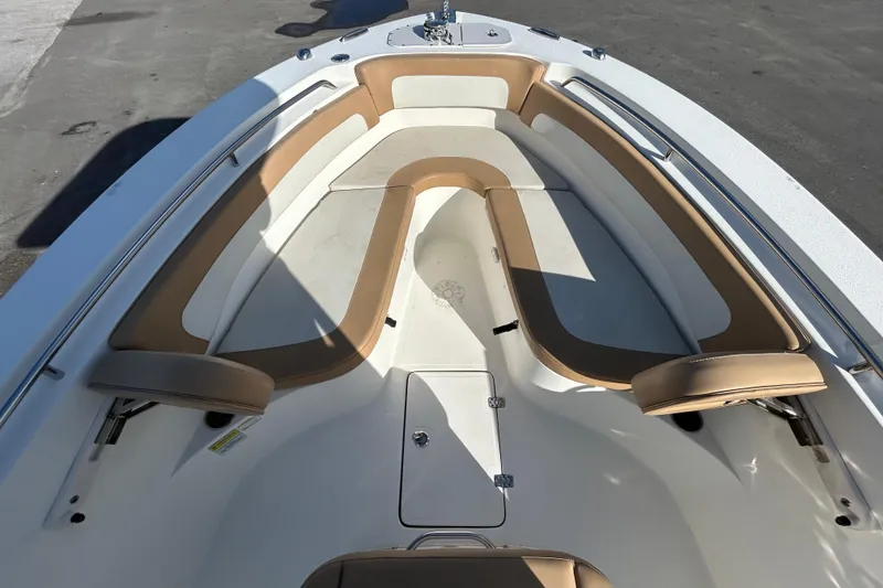 Slide: The Image of 2016 NauticStar 25 XS boat interior with tan cushioned seating and storage compartments. - 27