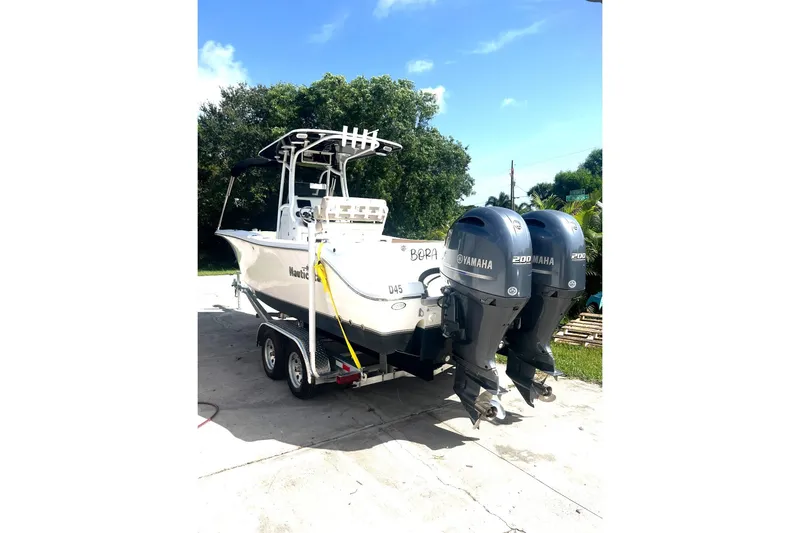 Slide: The Image of 2016 NauticStar 25 XS boat with dual Yamaha 200 engines, parked outdoors. - 3