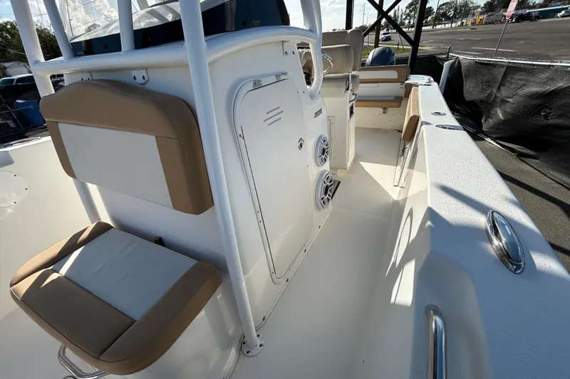 Slide: The Image of 2016 NauticStar 25 XS boat interior with seating and console, docked outdoors. - 36