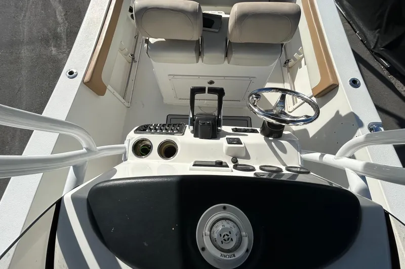 Slide: The Image of 2016 NauticStar 25 XS boat cockpit with steering wheel and control panel. - 38