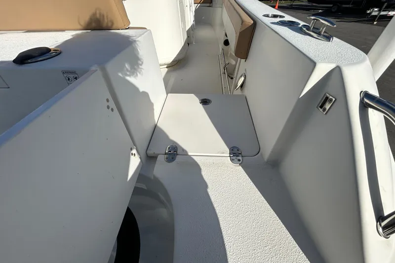Slide: The Image of 2016 NauticStar 25 XS boat interior with white deck and storage compartment. - 46