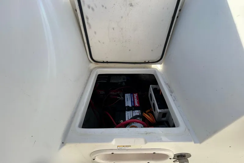 Slide: The Image of 2016 NauticStar 25 XS boat battery compartment with visible wiring and components. - 50