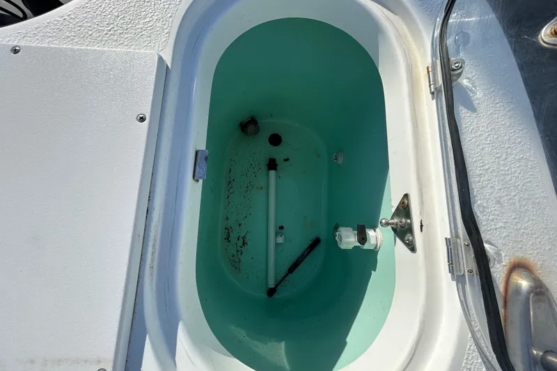Slide: The Image of Open storage compartment on 2016 NauticStar 25 XS boat, showing interior details. - 59
