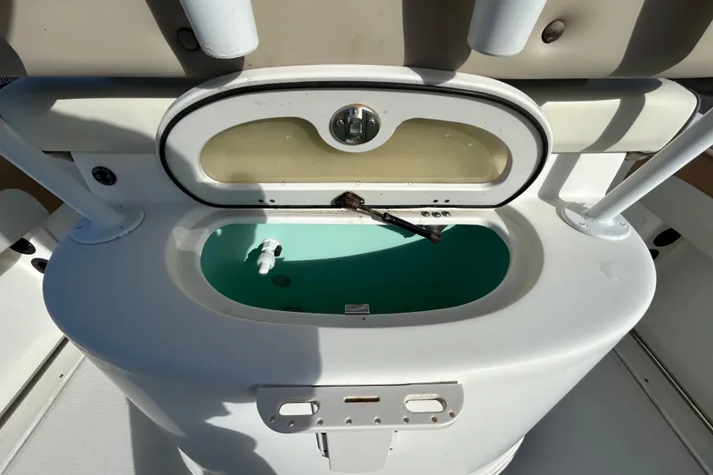 Slide: The Image of 2016 NauticStar 25 XS boat livewell with open lid and rod holders. - 61