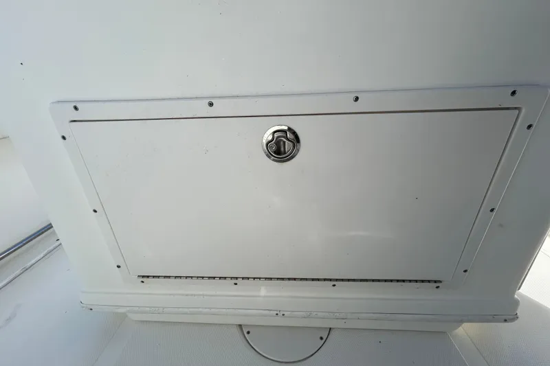 Slide: The Image of 2016 NauticStar 25 XS boat storage compartment with metal latch. - 67