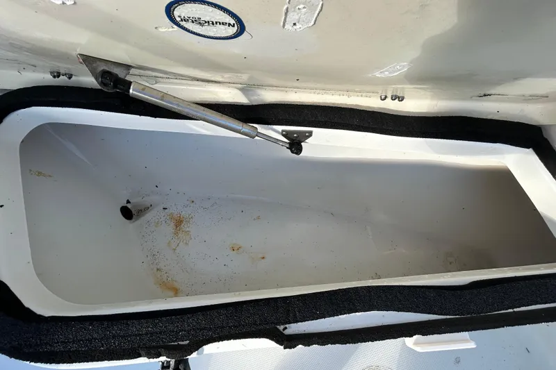 Slide: The Image of Open storage compartment in 2016 NauticStar 25 XS boat, showing interior details. - 95
