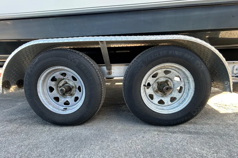 Slide: The Image of Trailer wheels of a 2016 NauticStar 25 XS boat on a concrete surface. - 97