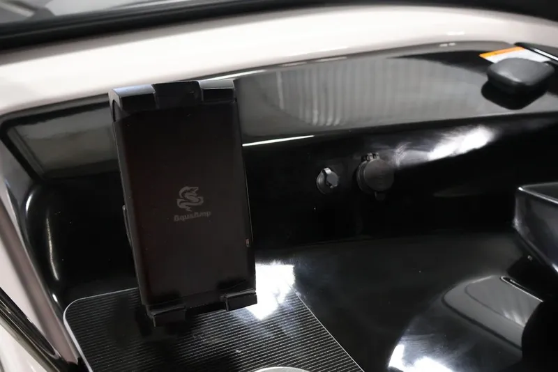 Slide: The Image of Dashboard of 2026 Yamaha Boats 255XE featuring a phone holder and controls. - 31