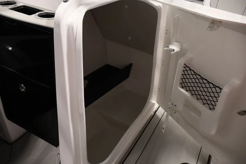 Slide: The Image of 2026 Yamaha Boats 255XE interior storage compartment with netted pocket and cup holders. - 16