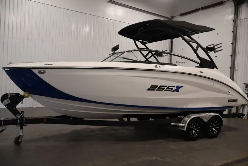 Slide: The Image of 2026 Yamaha Boats 255XE in showroom, sleek design, white and blue color scheme. - 40