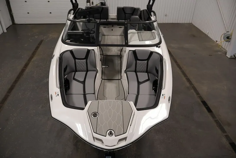Slide: The Image of 2026 Yamaha Boats 255XE interior, showcasing sleek seating and modern design in a showroom. - 47