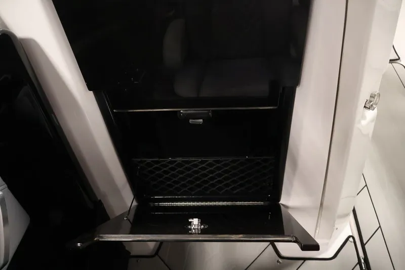 Slide: The Image of Interior storage compartment of 2026 Yamaha Boats 255XE, featuring sleek black design. - 42