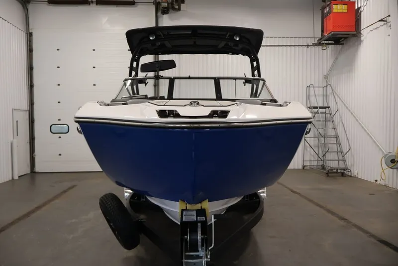 Slide: The Image of 2026 Yamaha Boats 255XE in a garage, showcasing sleek blue hull design. - 2