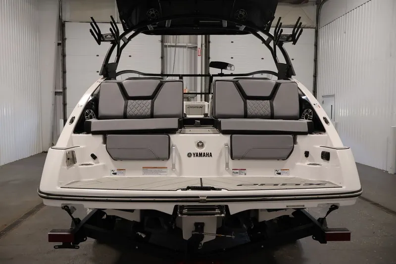 Slide: The Image of 2026 Yamaha Boats 255XE rear view in a garage, showcasing seating and design features. - 1