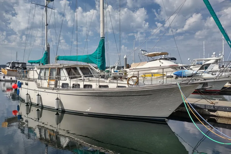 The Image of 1985 Siltala Nauticat 44 sailboat docked in a marina under a cloudy sky. - 0