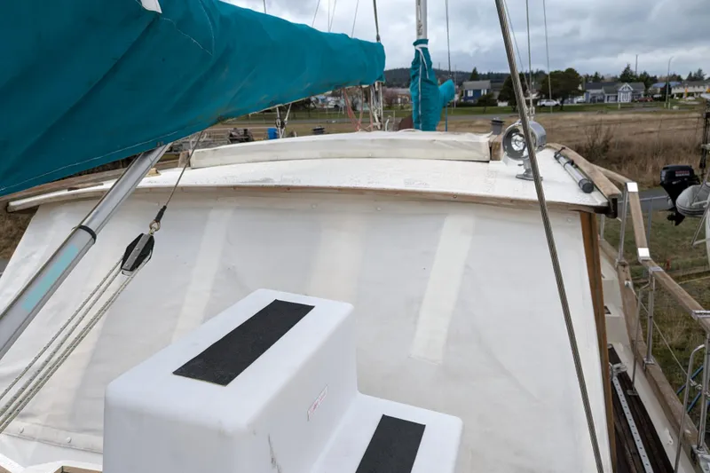 Slide: The Image of 1985 Siltala Nauticat 44 sailboat deck with blue sail cover, docked in a marina. - 16