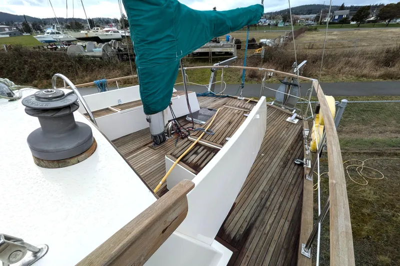 Slide: The Image of 1985 Siltala Nauticat 44 sailboat deck with wooden flooring and green sail cover. - 18