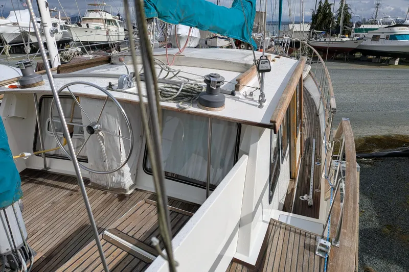 Slide: The Image of 1985 Siltala Nauticat 44 sailboat with wooden deck and blue sail cover in marina. - 21