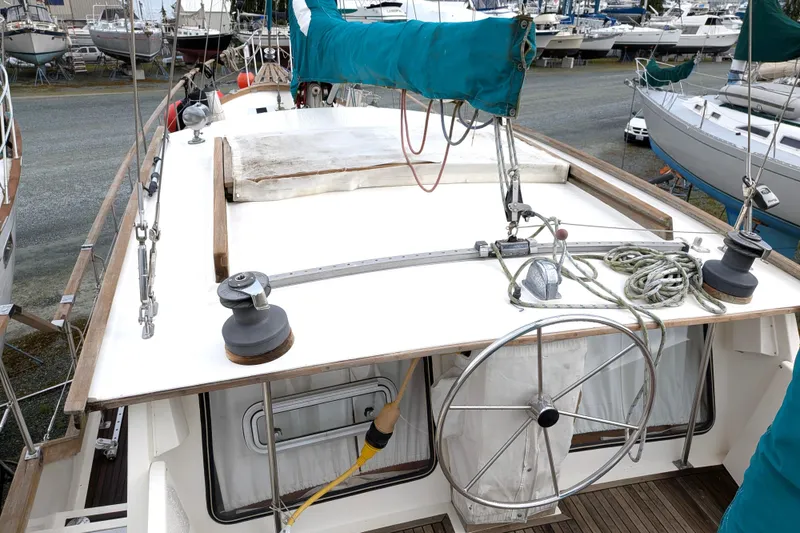 Slide: The Image of 1985 Siltala Nauticat 44 sailboat deck with steering wheel and rigging. - 23