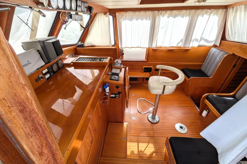 Slide: The Image of Interior of 1985 Siltala Nauticat 44 yacht with wooden helm and seating area. - 25