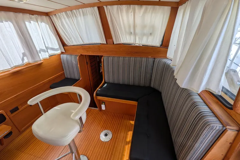 Slide: The Image of Interior of 1985 Siltala Nauticat 44 yacht with striped seating and wooden accents. - 28
