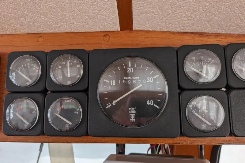 Slide: The Image of Dashboard gauges of a 1985 Siltala Nauticat 44 sailboat, displaying engine hours and tank levels. - 34