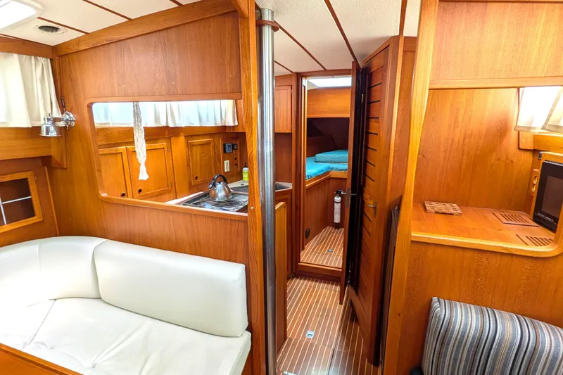 Slide: The Image of Interior of 1985 Siltala Nauticat 44 yacht with wood finish and cozy seating area. - 37
