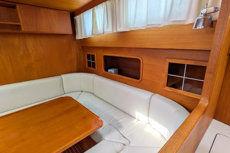 Slide: The Image of Interior of 1985 Siltala Nauticat 44 yacht with white seating and wooden accents. - 39