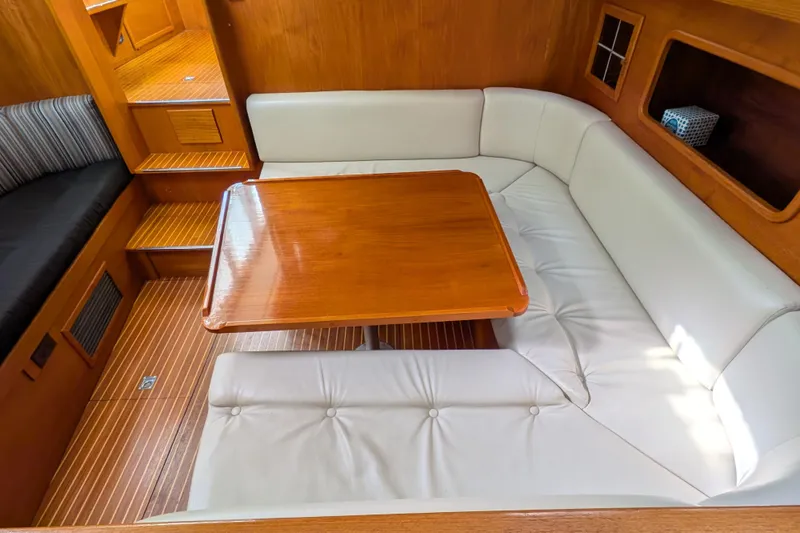 Slide: The Image of Interior of 1985 Siltala Nauticat 44 yacht with wooden table and white seating. - 44