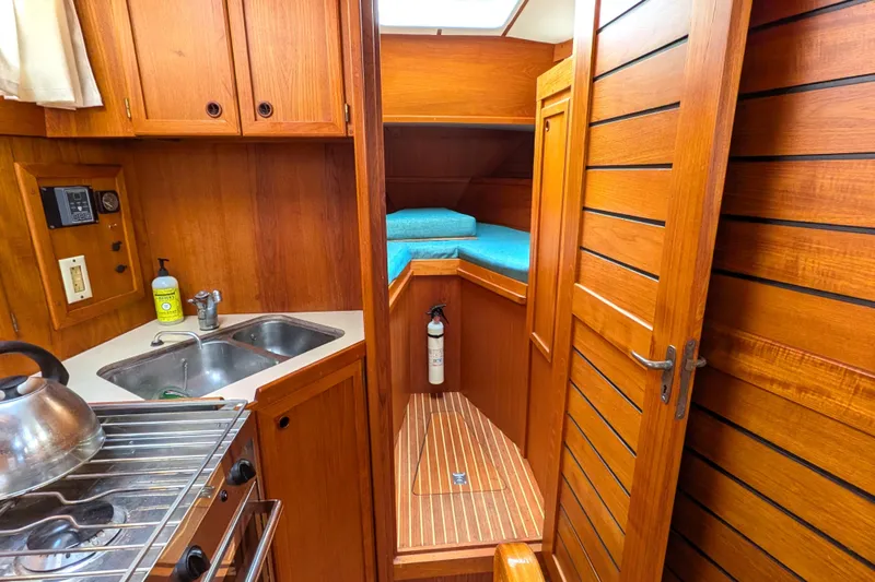 Slide: The Image of Interior of 1985 Siltala Nauticat 44 yacht with wooden cabinetry and compact kitchen. - 45