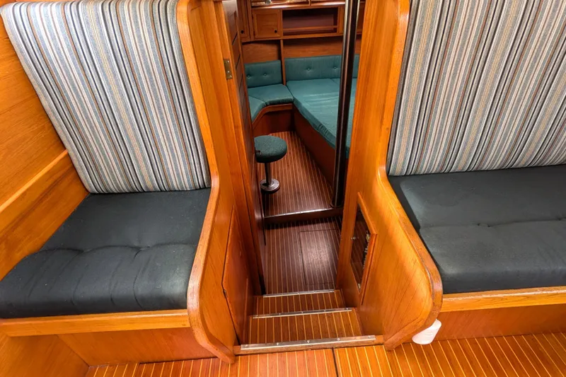 Slide: The Image of Interior of 1985 Siltala Nauticat 44 yacht with striped seating and wooden finish. - 53