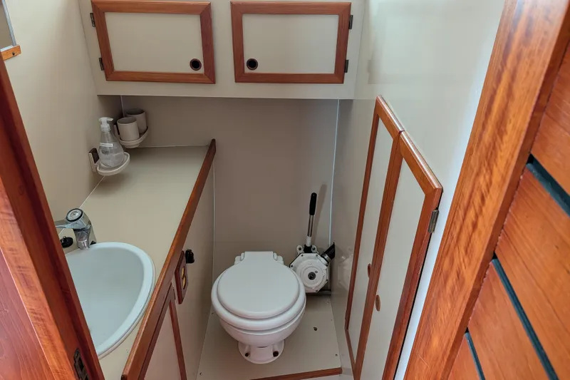 Slide: The Image of 1985 Siltala Nauticat 44 yacht bathroom with sink, toilet, and wooden cabinetry. - 60