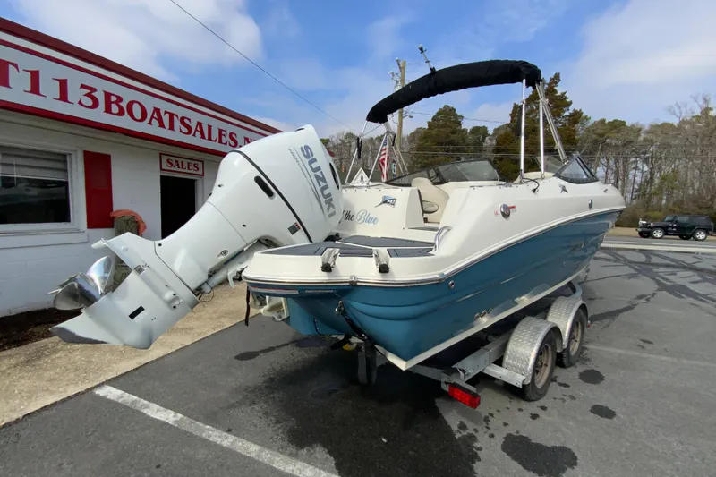 Slide: The Image of 2023 Stingray 231 DC boat with Suzuki outboard motor on trailer at dealership. - 10