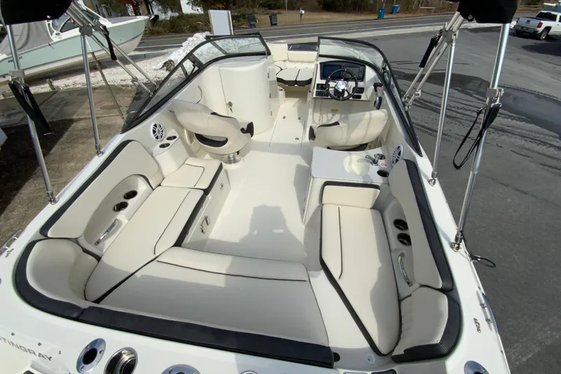 Slide: The Image of 2023 Stingray 231 DC boat interior with spacious seating and modern dashboard. - 11