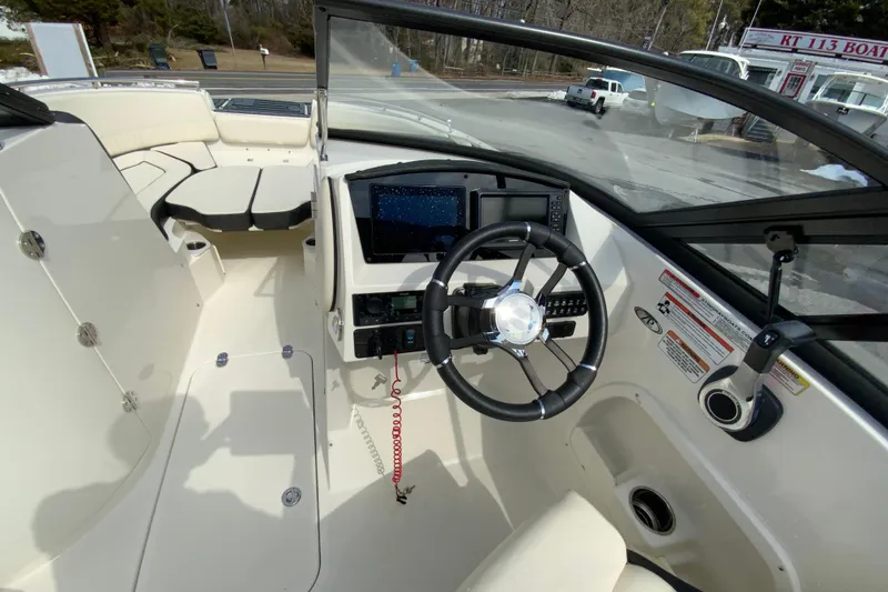 Slide: The Image of 2023 Stingray 231 DC boat interior with steering wheel and dashboard controls. - 12
