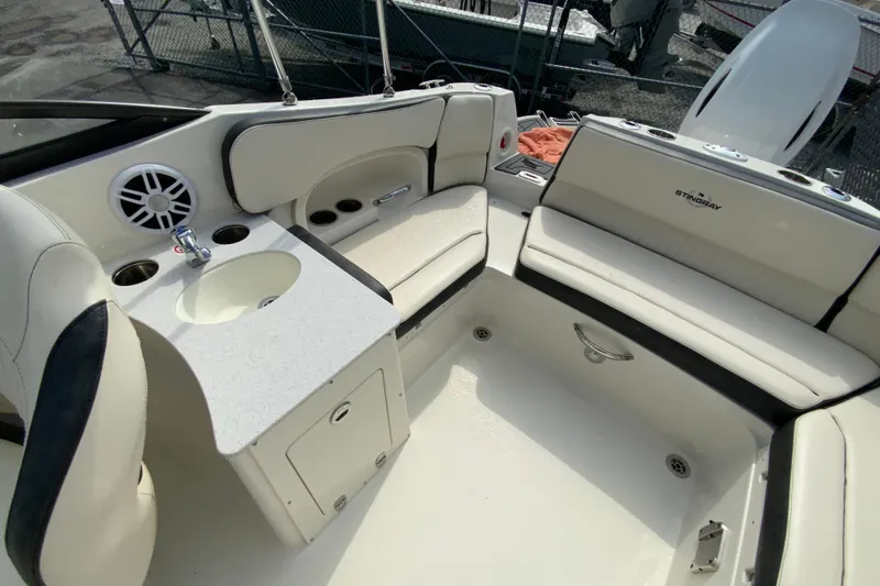 Slide: The Image of 2023 Stingray 231 DC boat interior with seating, sink, and speaker system. - 13