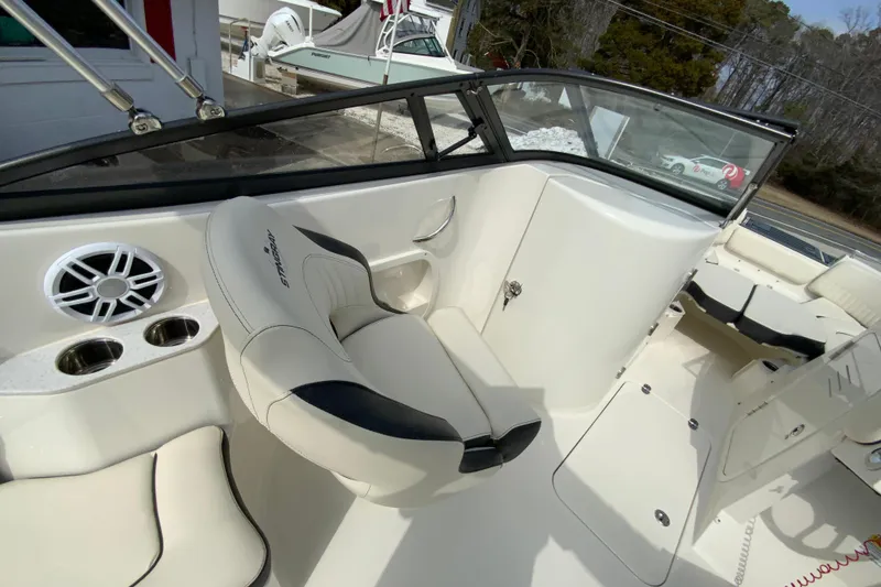 Slide: The Image of 2023 Stingray 231 DC boat interior with seating, cup holders, and speaker system. - 15