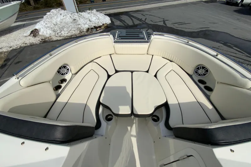 Slide: The Image of 2023 Stingray 231 DC boat interior with cream seating and cup holders. - 18