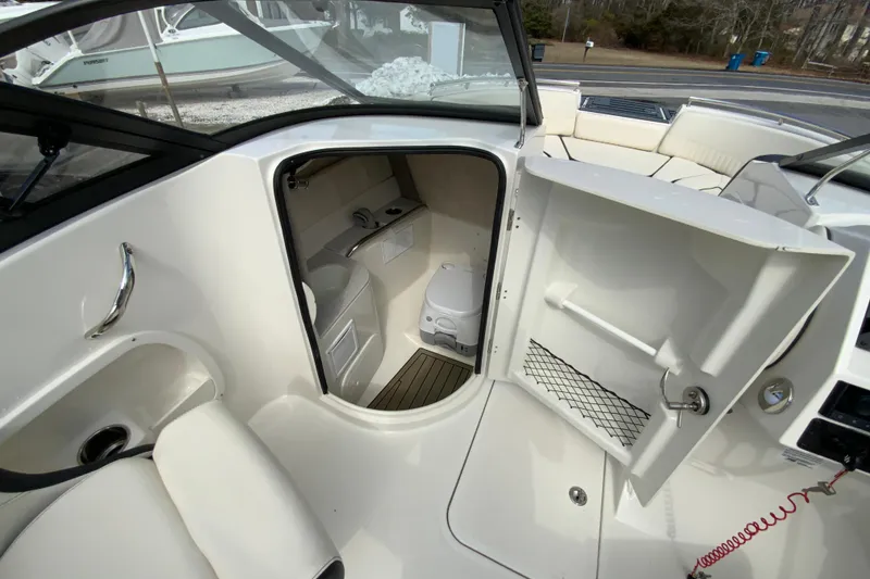 Slide: The Image of 2023 Stingray 231 DC boat interior with open cabin door and seating area. - 21